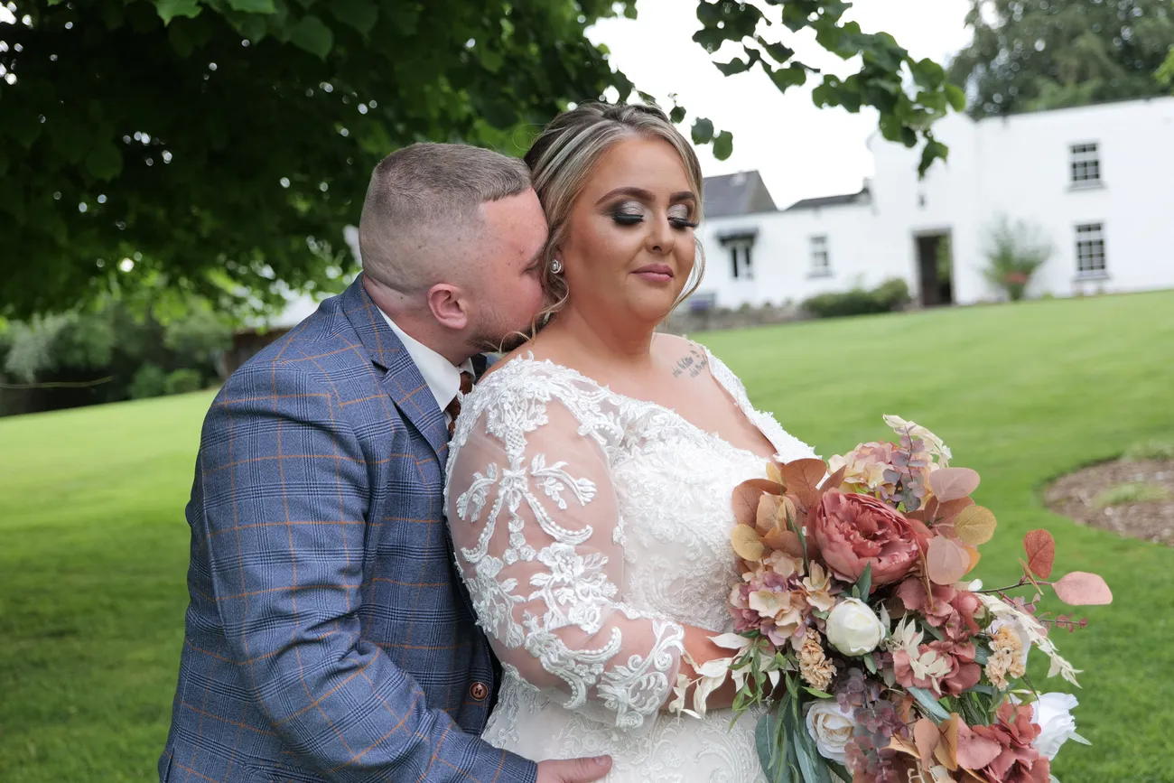 Country house wedding portrait with a bouquet and close embrace