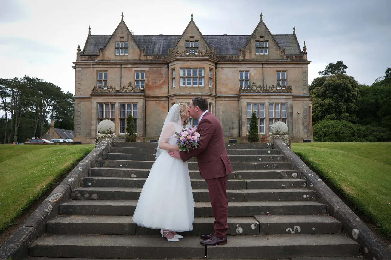 Couple portrait on the steps of a manor house