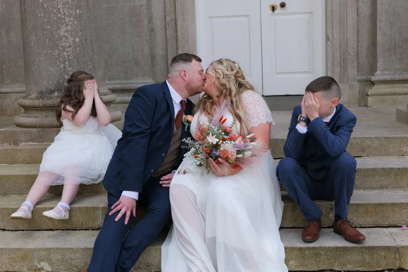 Wedding party laughing together on stone steps